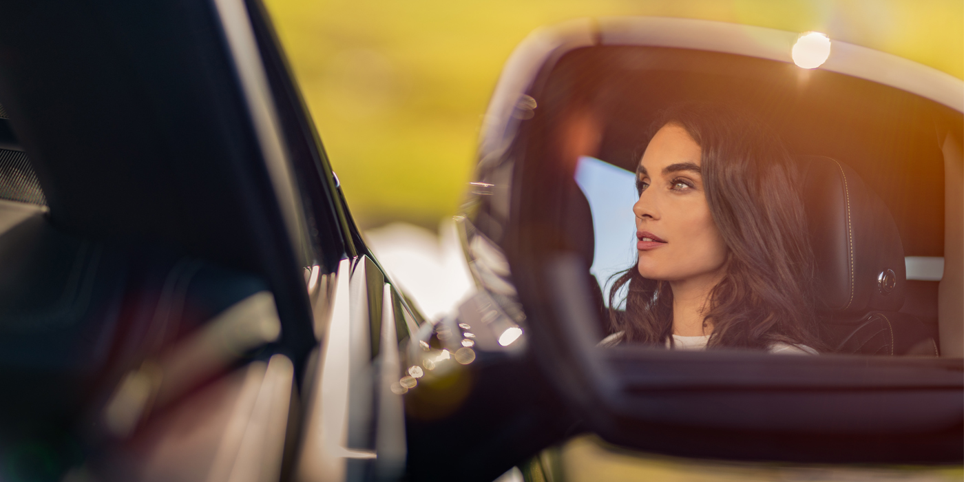 Bentley Guatemala profile of dark haired woman's face in mirror of Bentley car in sunlight
