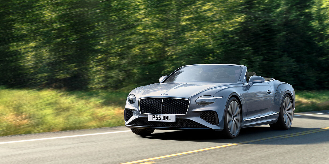 Bentley Guatemala New Bentley Continental GTC convertible front view in Silverlake paint with 22 inch ten spoke wheels, driving dynamically on a country road