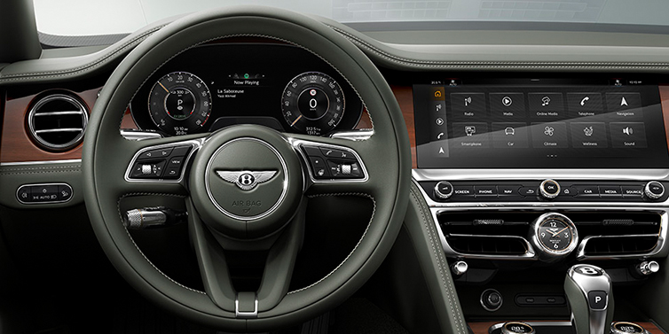 Bentley Guatemala New Bentley Flying Spur front cabin interior in Cumbrian green hide with Crown Cut walnut veneer showing steering wheel and driver controls